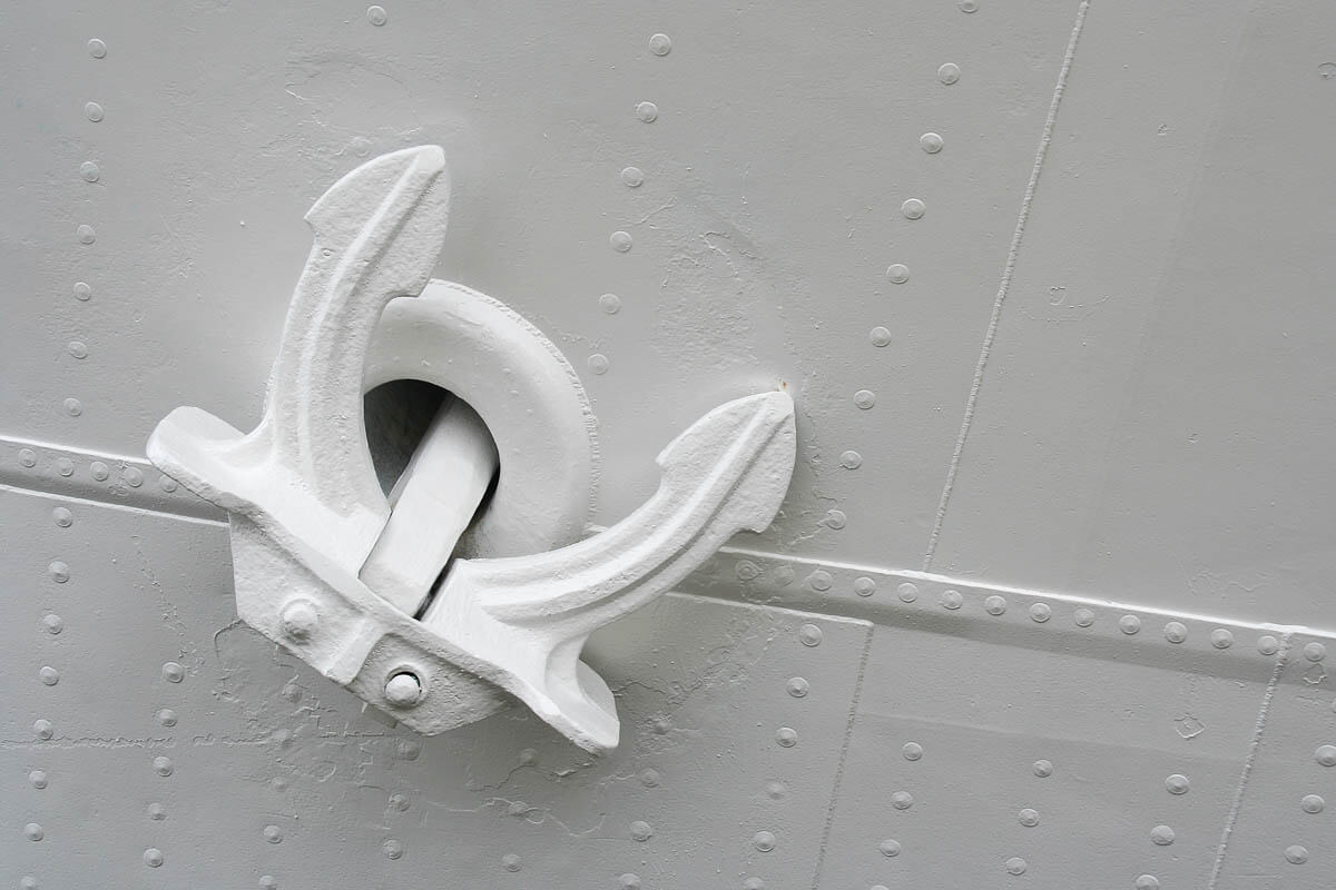Close-up of a main anchor of a white cruise ship.